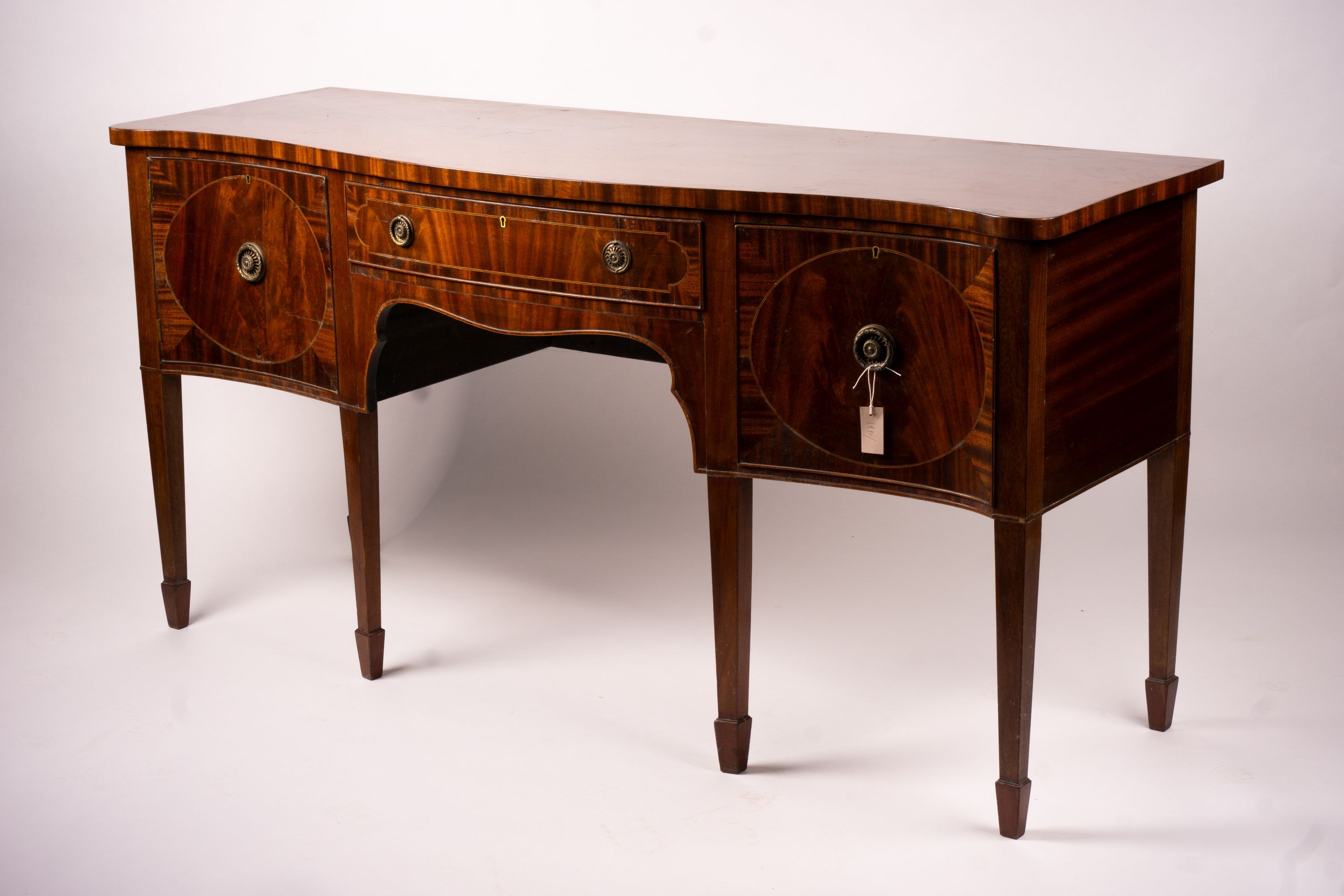 A George III style mahogany serpentine sideboard on square tapered legs, width 184cm, depth 63cm, height 93 cm